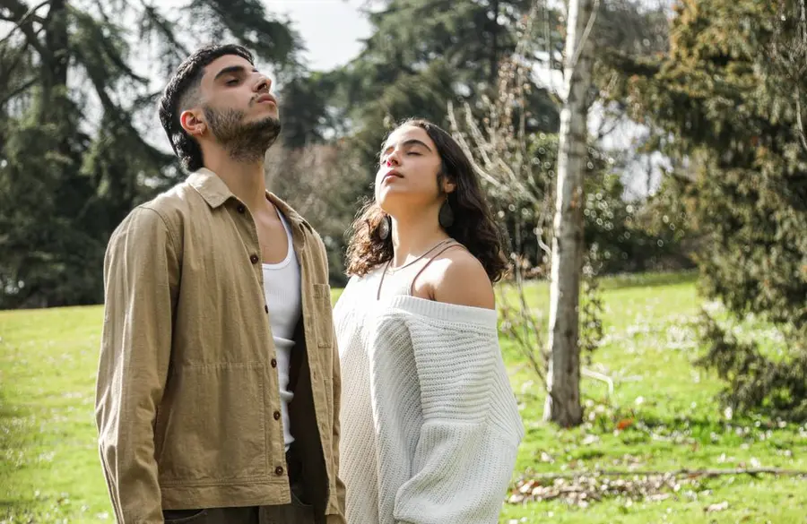 Two people practicing a calming breathing exercise outdoors